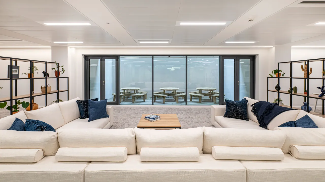 Breakout lounge with a large sofa and doors to the terrace