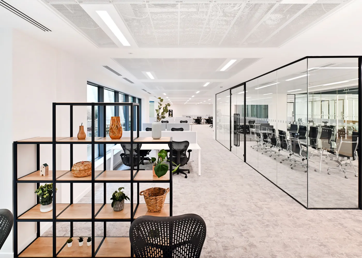 Open plan office space with shelving and glass meeting rooms